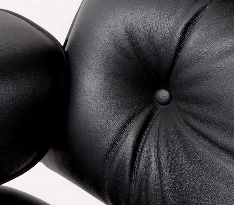 Close-up of the black aniline leather tufting on the Eames-style lounge chair cushions