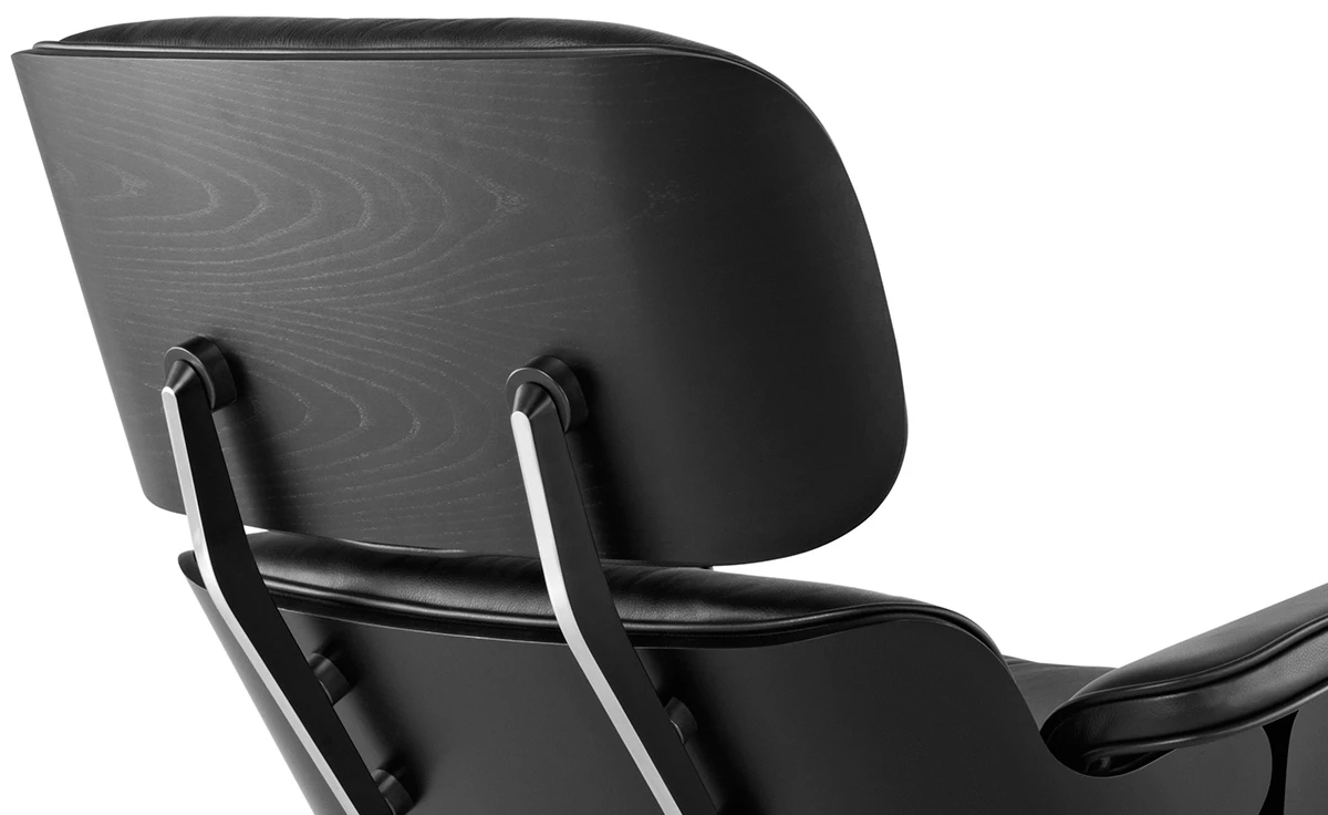 Standalone black leather ottoman footrest with ebony ash shell, matching the lounge chair